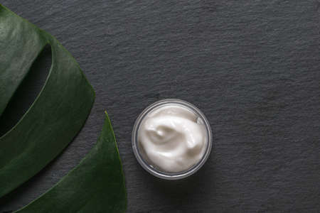 A sheet of monstera and a jar of cream on a stone background. Natural cosmetics and medicine .. Flat lay.の写真素材