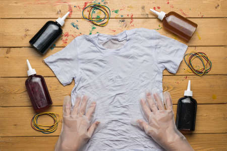 Women's gloved hands before dyeing tie dye t-shirts. The process of painting in the style of tie dye. Flat lay.の写真素材