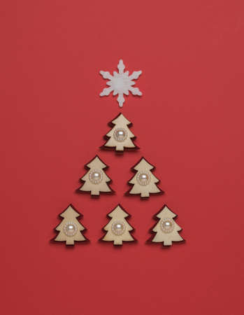 Creative image of a fir tree made of small figures with a snowflake on top. The minimum concept of...