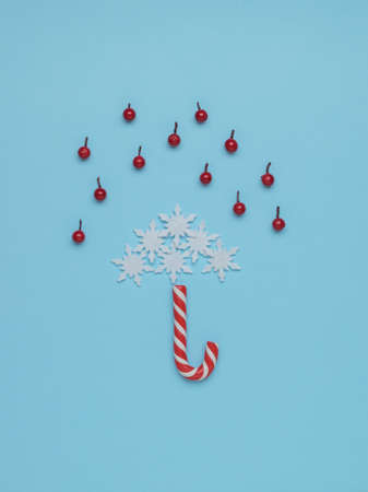 An umbrella made of sweets and snowflakes in the rain of berries. Minimalism. Contemporary art. The concept of the New Year.の写真素材