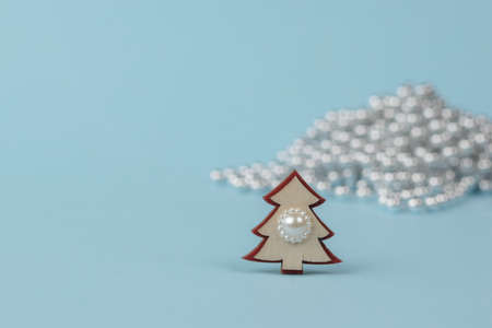 A small Christmas tree on the background of a large number of shiny balls. The minimum concept of...