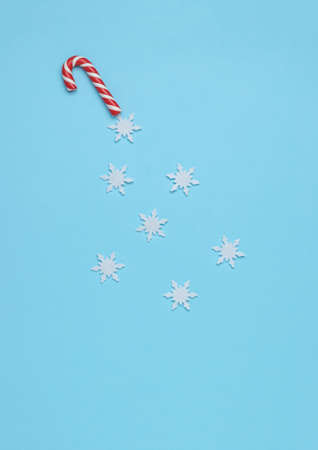 Beautiful white snowflakes flying out of Christmas sweets on a blue background. Minimalism. Contemporary art. The concept of the New Year.の写真素材