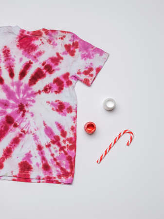 Tie dye-style short-sleeved T-shirt isolated on a white background. The background on the fabric is made with your own hands. Flat lay.の写真素材