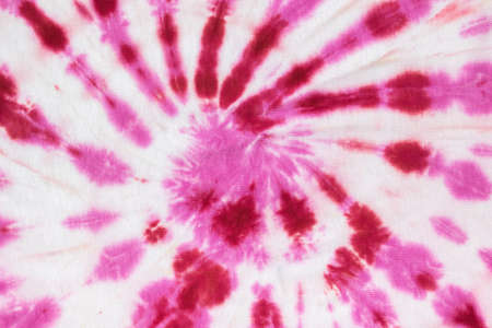 Red and white spiral pattern in tie dye style on the fabric made by hand. The background on the fabric is made with your own hands. Flat lay.の写真素材