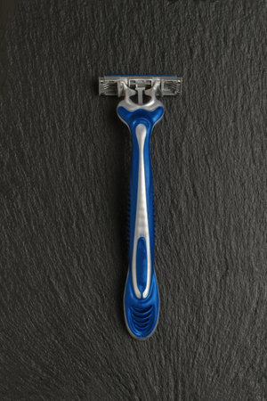 Stylish plastic razor on a dark stone background. Men's accessories for appearance care. Flat lay.の写真素材