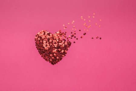 A brilliant flying heart on a red background. The concept of Valentine's Day. Flat lay.の写真素材
