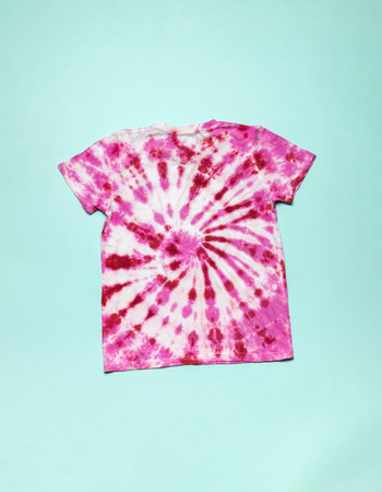 T-shirt with a spiral pattern in tie dye style on a blue background. Coloring clothes by hand at home. Flat lay.の写真素材