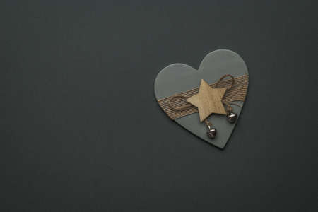 Wooden heart with a star on a dark gray background. Space for text. The concept of Valentine's Day.の写真素材