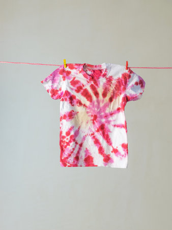 The T-shirt is dried on a clothesline after painting. Making clothes at home. Flat lay.の写真素材