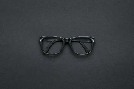 Classic black glasses on a dark gray background. Accessories for improving vision. flat lay.の写真素材