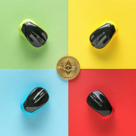 Four computer mice and a digital coin on a background of four colors. The concept of cryptocurrency...