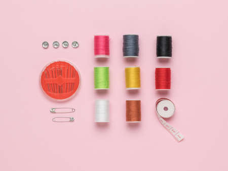 A set for home sewing and embroidery on a pink background. The concept of home needlework and...
