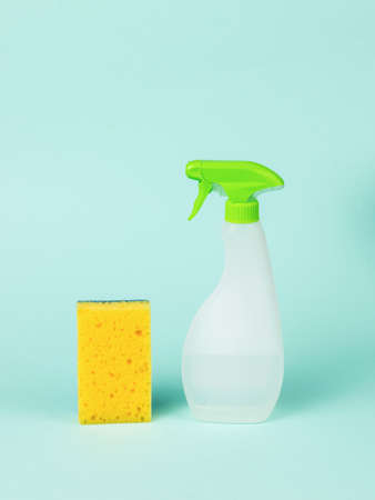 A plastic bottle with cleaning agent and a foam sponge on a blue background. cleaning kit.の写真素材