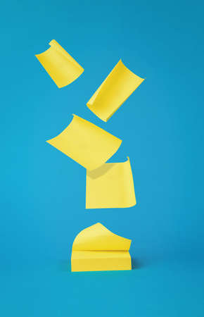 A stack of yellow paper notes is scattered on a blue background. Minimal concept of office supplies....