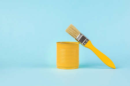 A brush and a yellow metal jar on a light blue background. A place for your text. Trending colors. Minimal concept of interior selection.の写真素材