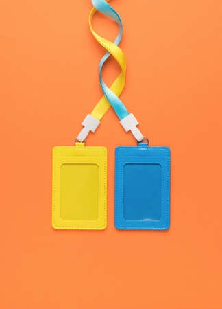 Yellow and blue badges on an orange background. name badge. A device for cards and business cards....