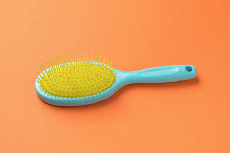 A bright yellow-blue combo on an orange background. A device for combing hair.の写真素材