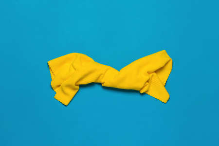 A bright yellow cleaning cloth on a blue background. Minimal concept of cleanliness. flat lay.の写真素材