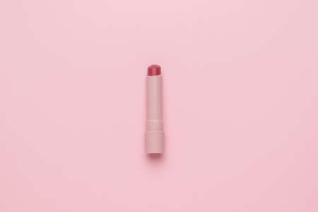 Light pink lipstick on a light pink background. Minimalist cosmetics concept. flat lay.の写真素材