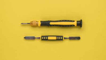 Yellow and yellow blade for repairing mobile devices on a yellow background. Accessories for repair....