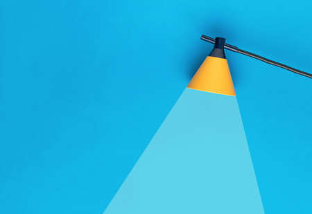 Yellow lamp with a beam of light on a blue background. Minimal business concept. Ray embodying the idea.の写真素材