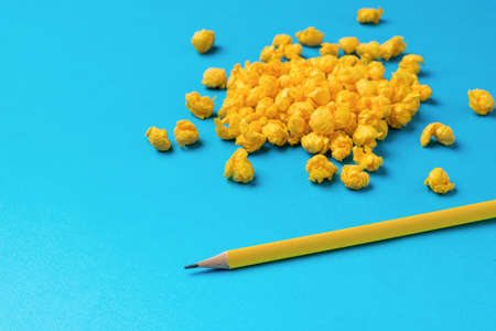 Minimal business concept. A bunch of crumpled pieces of paper and a yellow pencil on a blue background. A symbol of an idea.の写真素材