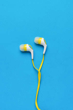 Classic headphones with a mobile phone wire on a blue background. minimal concept. flat lay.