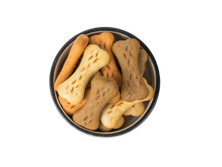 A bowl of cookies for dogs isolated on a white background. A delicious treat for dogs with cereals. flat lay.の写真素材