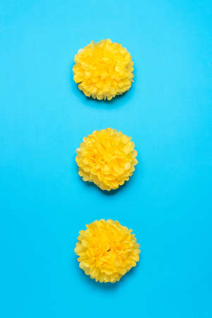 Three large paper pompoms on a blue background. Minimal party concept. flat lay.の写真素材