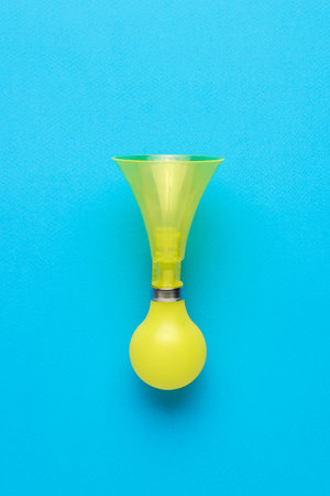 Retro bicycle horn in yellow on a blue background. An accessory for warning about danger. flat lay.の写真素材
