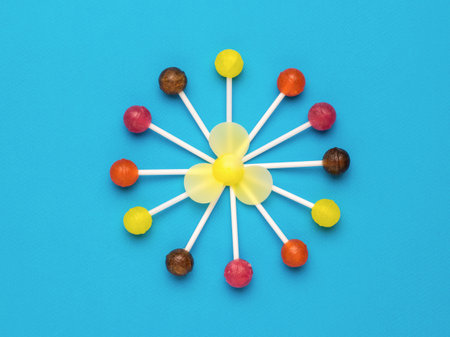 Lollipops nested in the shape of a circle with a propeller on a blue background. minimal concept. sweet candies. flat lay.の写真素材