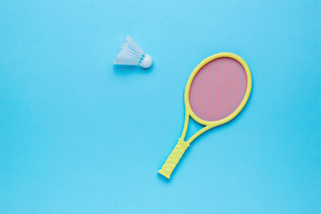 Badminton shuttlecock and yellow racket on a blue background. Minimal sports concept. flat lay.の写真素材