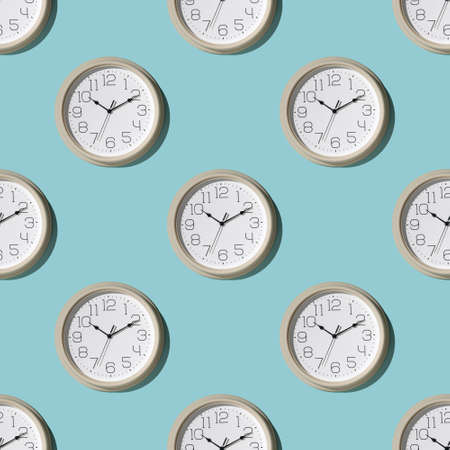 Seamless pattern of a large wall clock on a blue background. Minimal time concept.の写真素材