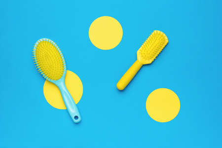 Two massage combs on an abstract yellow-blue background. Minimal hair care concept. flat lay.の写真素材