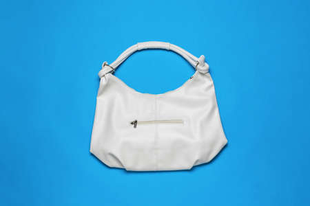 A large white leather bag on a blue background. Minimal concept of women's accessories. flat lay.の写真素材