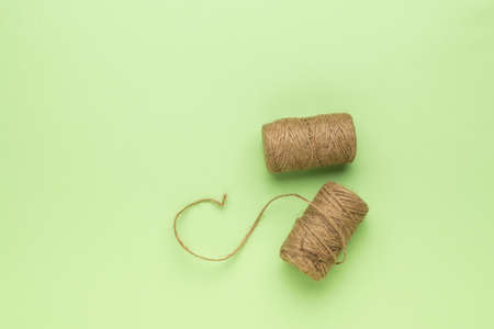 Two coils with coarse thread on a light green background. Minimal business concept.の写真素材