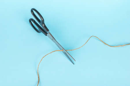 Top view of scissors cutting the thread. Minimal business concept.の写真素材