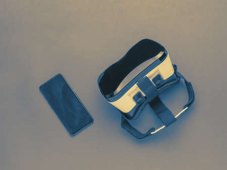 Tinted image of vr glasses and smartphone on an abstract background. A popular virtual reality gadget. flat lay.の写真素材