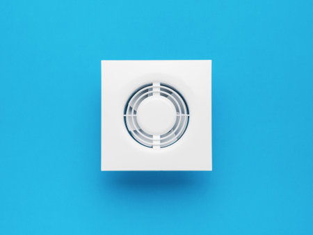 Stylish white wall fan on a blue background. Minimal ventilation concept. flat lay.