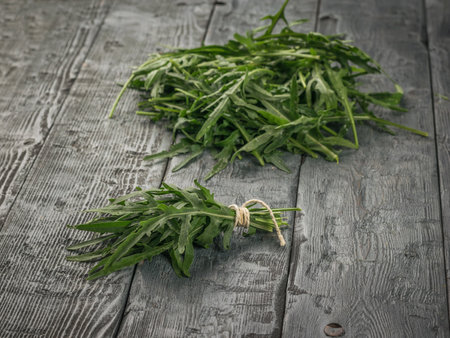 A bunch of arugula near a pile on a wooden table. Vitamin vegetarian food.の写真素材