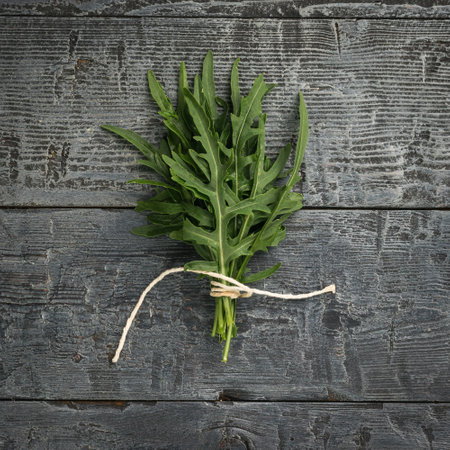 Arugula leaves tied with rope on a wooden background. Vitamin vegetarian food. flat lay.の写真素材