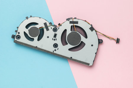 A laptop cooler with two fans on a pink and blue background. The concept of computer repair.の写真素材