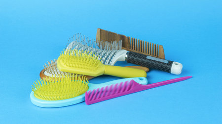 A bunch of a set of combs on a light blue background. Accessories for hair care. flat lay.の写真素材