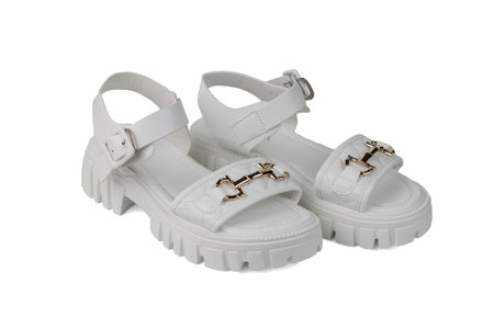 White leather sandals with metal clasps isolated on a white background. The concept of summer women's shoes.の写真素材