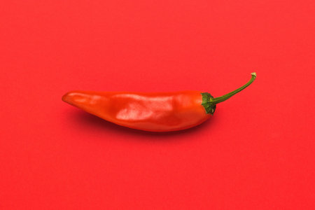 Bright red hot pepper on a bright red background. A popular spice. flat lay.の写真素材