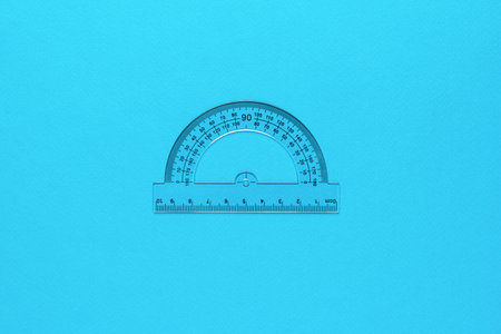 Transparent tool for measuring angles on a blue background. Minimal concept of measuring instruments.の写真素材