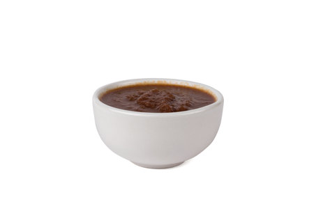 Red sauce in a white bowl isolated on a white background. The minimal concept of a universal seasoning.の写真素材