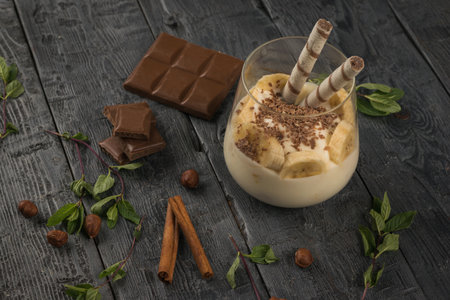 Banana dessert with cookies, chocolate and nuts on a wooden table. A delicious and nutritious natural dish.の写真素材