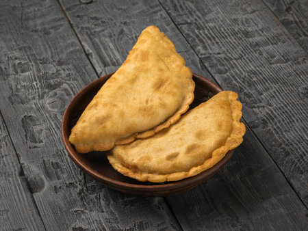 Fresh toasted pasties in a clay cup on a wooden table. The minimum concept of bakery products with meat.の写真素材