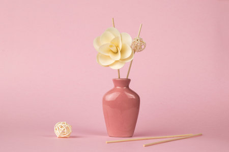Decoration of flowers and incense sticks on a pink background. The minimal concept of creating fragrances.の写真素材